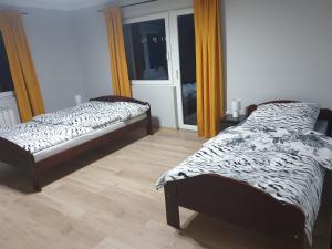 a bedroom with two beds and a window with at Noclegi w gorcach in Ponice