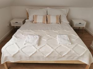 Una cama con sábanas blancas y almohadas. en Hygge House, en Zator