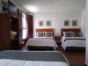 a hotel room with two beds and a window at HOTEL CASA SILVESTRE in Zacatlán +14 photos