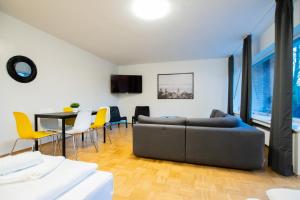メーアブッシュにあるRAJ Living - 1 , 3 and 4 Room Apartments - 20 min Messe DUS & Airport DUSのリビングルーム(ソファ、テーブル、椅子付)