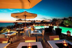 a restaurant with tables and chairs and a swimming pool at Tenuta Del Poggio Antico in Ischia