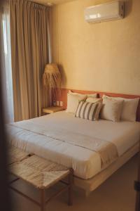 a bedroom with a large bed with a window at Casa Peregrino Holbox in Holbox Island