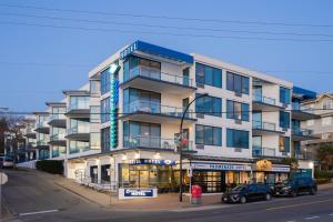 a building on a street with cars parked in front of it at Ocean Promenade Hotel in White Rock