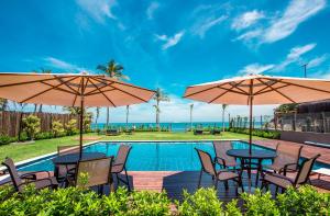 a pool with tables and chairs and umbrellas at Residencial Marina Del Sol in Pauba