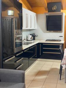 a kitchen with a black refrigerator and white cabinets at Cozy home in Pertegada +8 photos