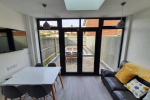 a living room with a table and a couch at Oole 2 bed & en-suites house with parking near beach in Cleethorpes