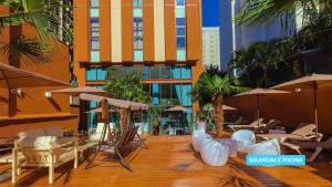 Un patio con sillas y sombrillas en un edificio. en Vila Galé Paulista, en São Paulo