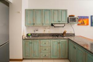 a kitchen with green cabinets and a sink at Hermoso Apartamento Frente al Mar 2 Habitaciones PAZ122 in Coveñitas