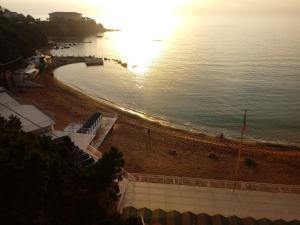 a beach with the sun shining on the water at Caletta Beach in Castiglioncello