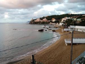 a view of a beach with buildings and the ocean at Caletta Beach in Castiglioncello