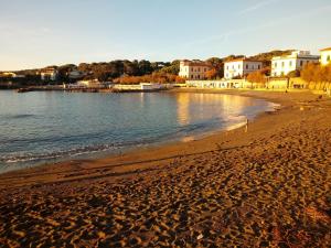 a sandy beach with houses and the water at Caletta Beach in Castiglioncello