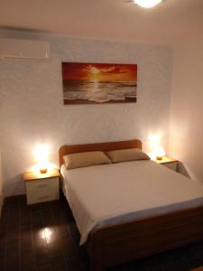a bedroom with a bed and two lights on two tables at Caletta Beach in Castiglioncello +37 photos