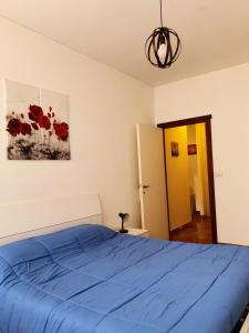 a bedroom with a blue bed and a painting of red flowers at Centre Home in Rapallo