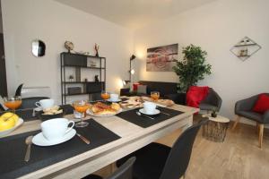 una sala de estar con una mesa con comida. en Le Refuge by EasyEscale, en Romilly-sur-Seine
