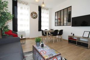 a living room with a couch and a table at Le Refuge by EasyEscale in Romilly-sur-Seine