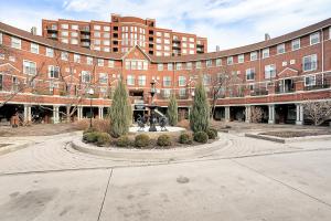 a large brick building with two people walking in front of it at Kasa Downtown Louisville in Louisville