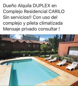 una foto de una piscina con dos sillas al lado en DUPLEX Casa 100 m2 CARILO HOUSE Complejo Residencial Sin Serv en Cariló