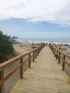 un paseo marítimo de madera que conduce a la playa en DUPLEX Casa 100 m2 CARILO HOUSE Complejo Residencial Sin Serv en Cariló