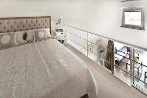 a white bedroom with a large bed and a staircase at Tenuta Del Poggio Antico in Ischia
