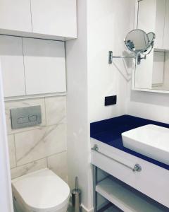 a bathroom with a toilet and a sink and a mirror at ORBI City studio 536 in Batumi