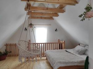 a swing in a room with a bed and a window at Planinska kuca Bjelasnica in Sinanovići