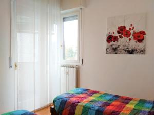 sypialnia z kolorowym łóżkiem i oknem w obiekcie Sun Flat w Rapallo