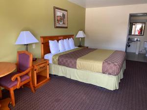 格伦代尔Chariot Inn Glendale - Pasadena的一间配有床、桌子和椅子的酒店房间