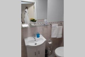 a white bathroom with a sink and a mirror at Mews with garden views in Carlow