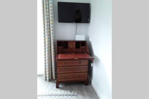 a dresser with a television on top of it at Mews with garden views in Carlow