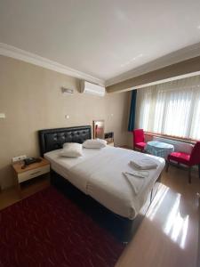 a bedroom with a large bed with a red rug at Bordo Hotel in Trabzon