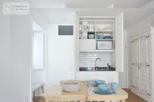 a kitchen with a table with blue dishes on it at A Botoeira da Praça guest house in Viana do Castelo
