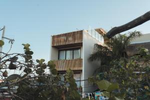 a building with a balcony and a palm tree at Casa Peregrino Holbox in Holbox Island