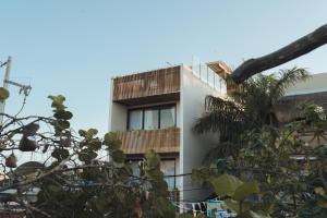 un edificio con balcón y una palmera en Casa Peregrino Holbox, en Isla Holbox