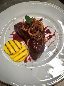 a plate of food with a piece of meat and bananas at Isola Blu in Taranto