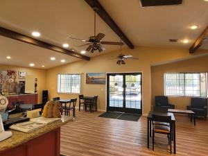 a living room with tables and chairs and a ceiling fan at Days Inn by Wyndham Willcox in Willcox