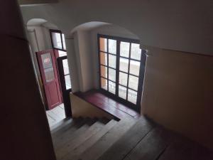 an empty hallway with two windows and a red door at Apartments XVII Century in Lviv