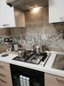 una cocina con 2 ollas en una estufa en Cristel Malpensa apartment, en Cardano al Campo