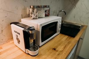 a microwave sitting on a counter next to a coffee maker at Garden Apartament Petrila in Petrila
