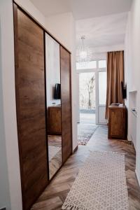 a room with a large wooden door with a mirror at Garden Apartament Petrila in Petrila
