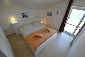 a bedroom with a bed with two boxes on it at Apartments Denko - right on the beach in Betina
