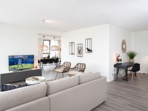 a white living room with a couch and a dining room at Sea view apartment in Den Haag with terrace in Scheveningen