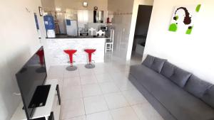 a living room with a couch and two red stools at Ap06-A 50 Metros da Praia Flats Mobiliados para 4 Pessoas in Paulista +4 photos