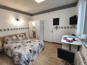 a bedroom with a bed and a table in it at Studio éco proche du phare in Calais