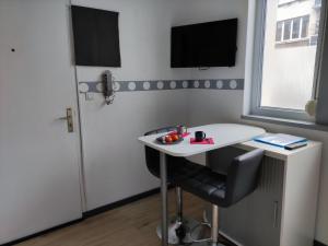 a room with a table and a tv on a wall at Studio éco proche du phare in Calais