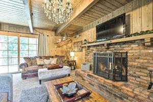 Cute Cabin and Deck Less Than 2 Mi to Lake Arrowhead Village في ليك أروهيد: غرفة معيشة مع موقد حجري وتلفزيون