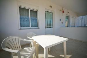 einen weißen Tisch und zwei Stühle in einem Zimmer in der Unterkunft Studio Anthoula in Kefalos