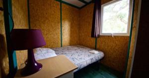 Habitación pequeña con cama y ventana en Location de chalet Meremaki en Pianottoli-Caldarello