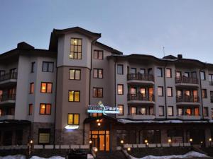 a large apartment building in the snow at night at Studio Villa Park 408 in Borovets