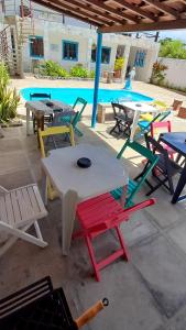 - un groupe de tables et de chaises à côté d'une piscine dans l'établissement Ap08-A 50 Metros da Praia Flats Mobiliados para 4 Pessoas, à Paulista