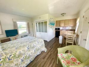 a bedroom with a bed and a table and a kitchen at Surf Studio Beach Resort in Cocoa Beach